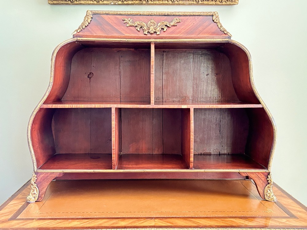 A Louis XV style rosewood desktop cartonnier featuring open compartmentalised shelves and gilded ormolu mounts along the crest and feet. View VI