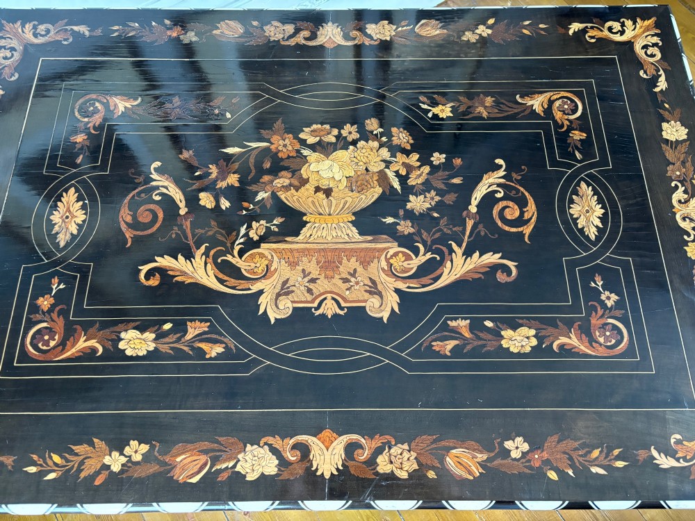 A 19th-century Dutch ebonised rectangular table featuring detailed floral marquetry, bone inlay edging, barley twist legs, and an X-frame stretcher. View X