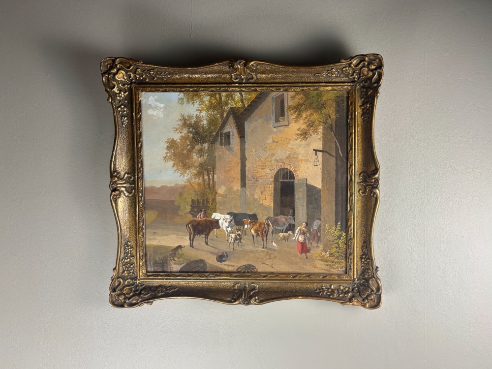 A framed gouache painting depicting a rural farmyard scene with livestock and rustic stone buildings set within an ornate gilded frame. View II