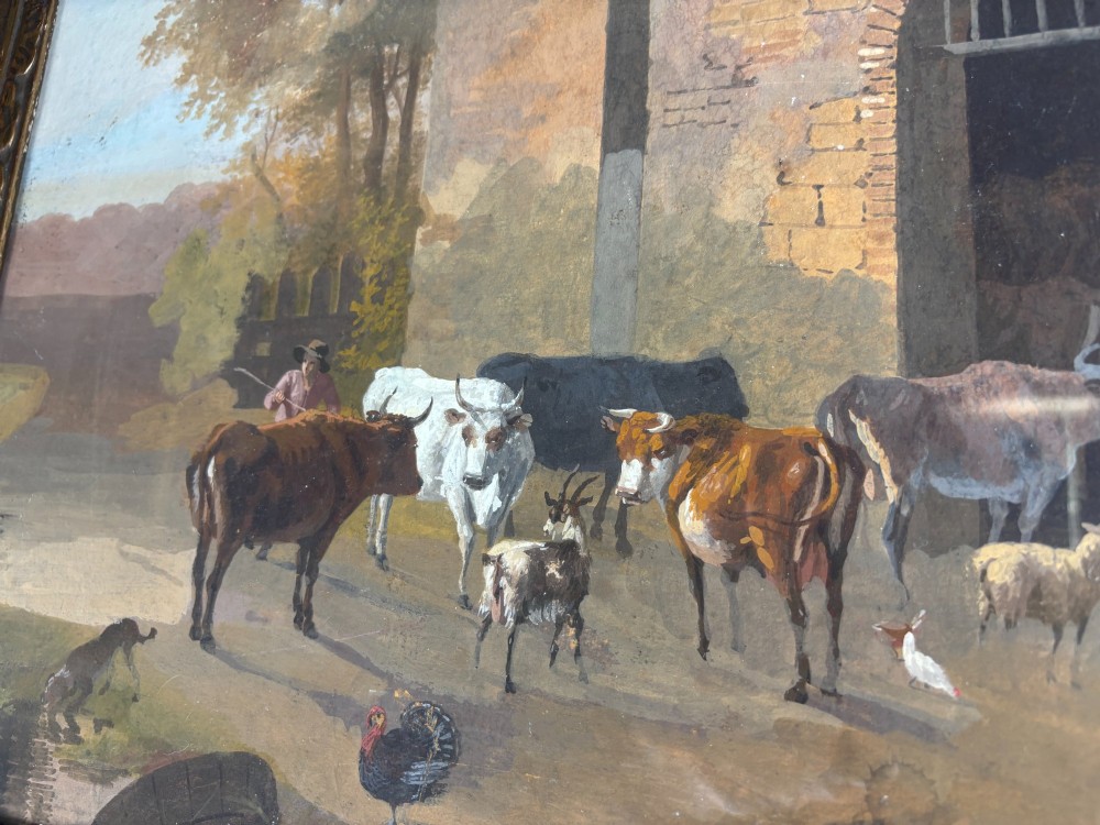 A framed gouache painting depicting a rural farmyard scene with livestock and rustic stone buildings set within an ornate gilded frame. View V