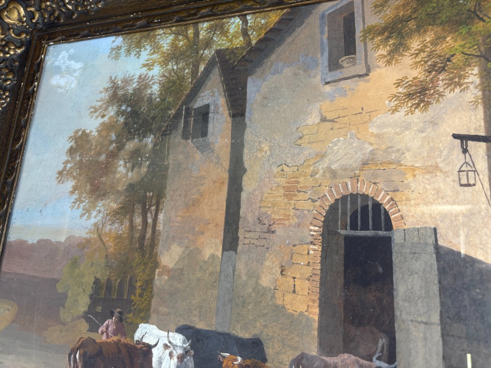 A framed gouache painting depicting a rural farmyard scene with livestock and rustic stone buildings set within an ornate gilded frame. View VI