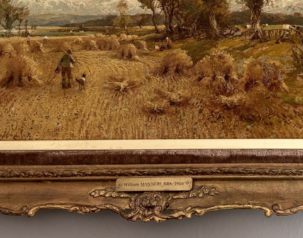 A Victorian landscape oil painting depicting a harvest field with haystacks and a figure, enclosed in an ornate gilded frame with a velvet slip. View IV