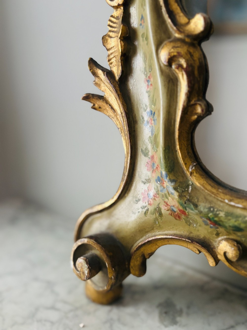 A mid-19th century Italian Venetian wall mirror featuring a carved giltwood frame with scrolling cresting, a sage green polychrome finish, and hand-painted floral detail. View II