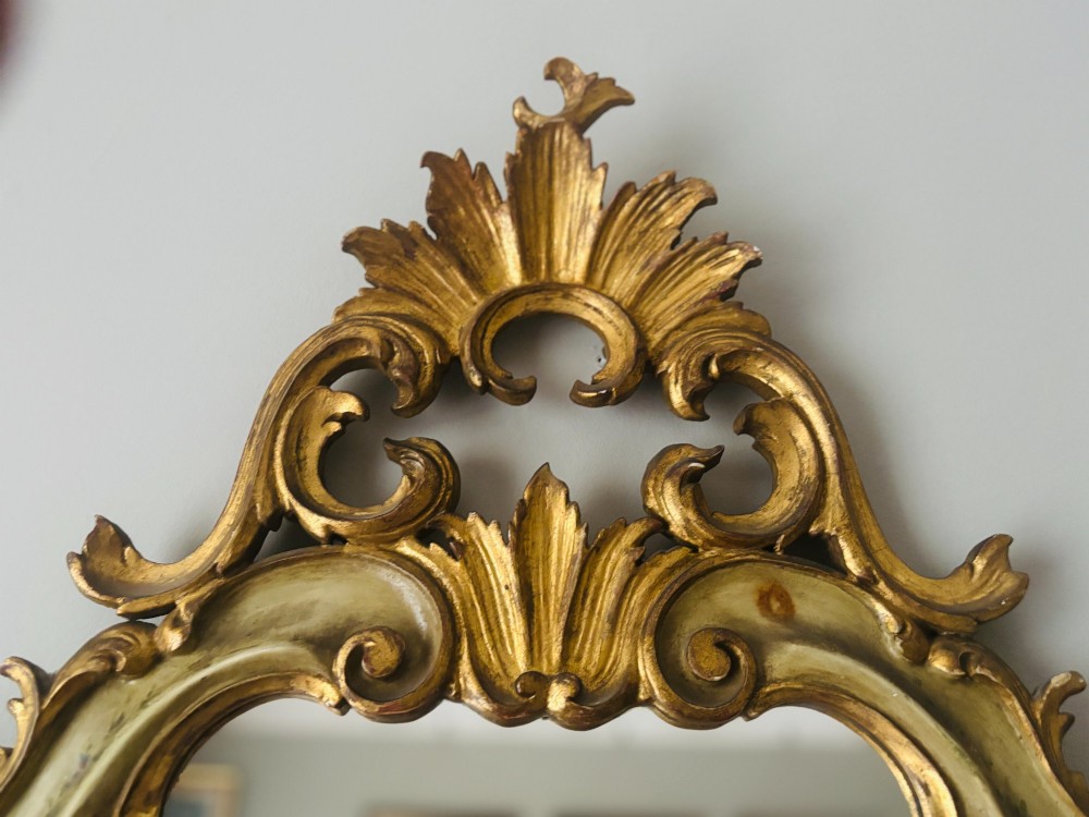 A mid-19th century Italian Venetian wall mirror featuring a carved giltwood frame with scrolling cresting, a sage green polychrome finish, and hand-painted floral detail. View VIII
