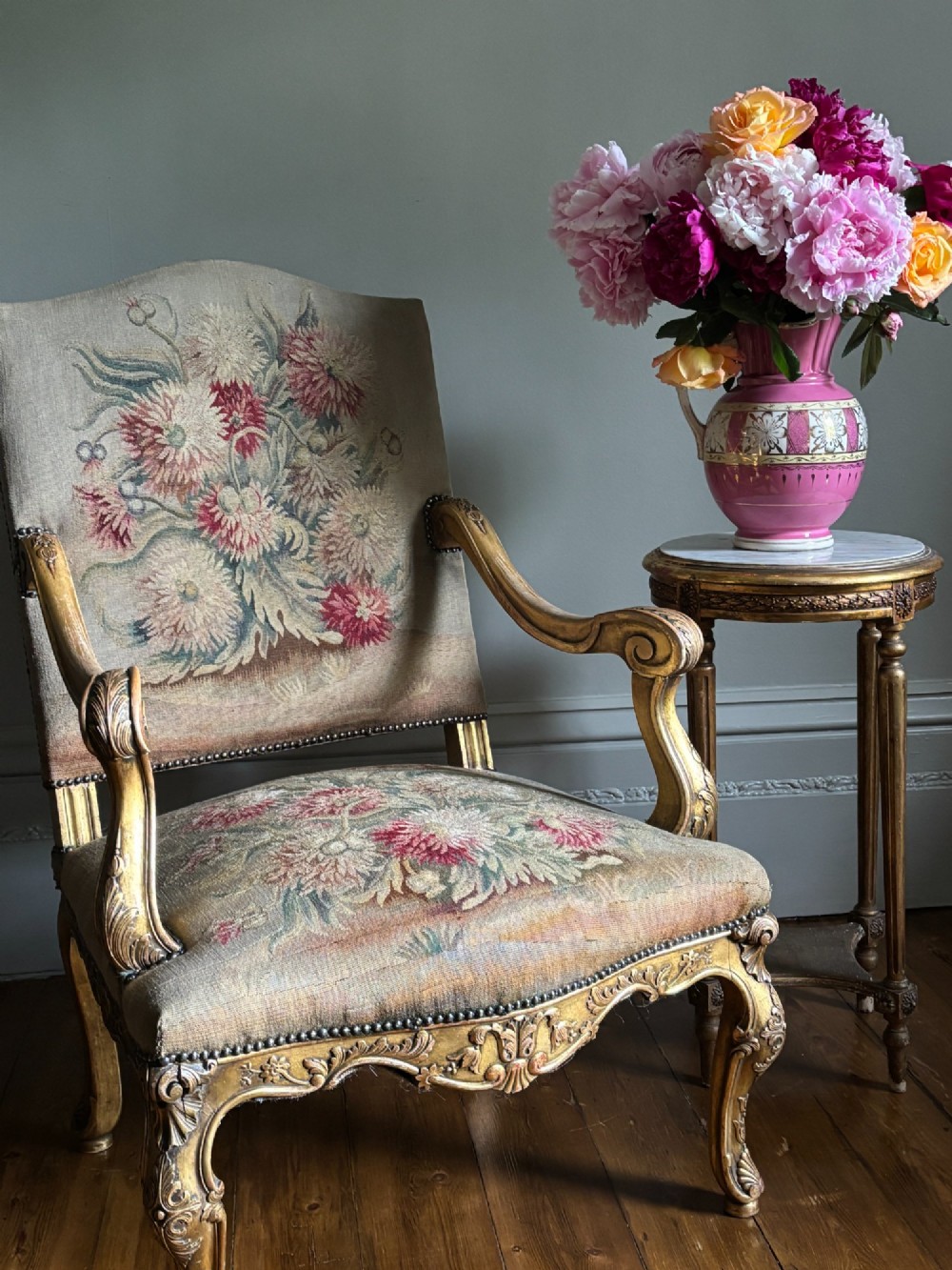 A late nineteenth-century French Regence style giltwood open armchair featuring floral tapestry upholstery and carved cabriole legs. View IV