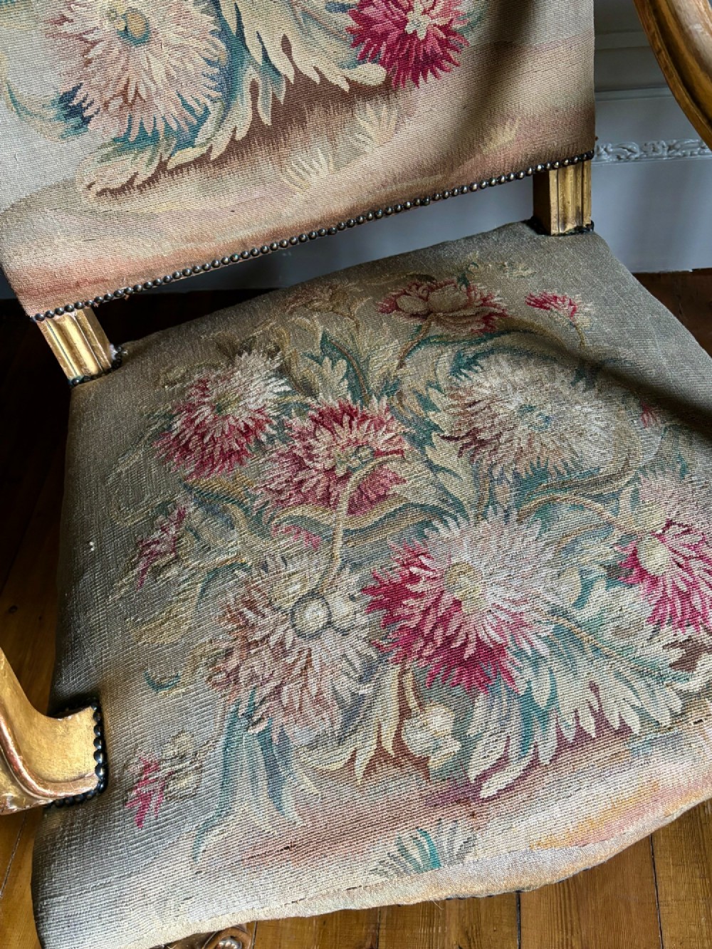 A late nineteenth-century French Regence style giltwood open armchair featuring floral tapestry upholstery and carved cabriole legs. View VI