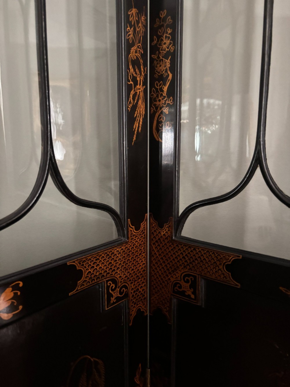 A four-panel black lacquered coromandel screen featuring Chinese Chippendale pagoda crestings, arched glazed tracery windows, and gilt landscape scenes. View X