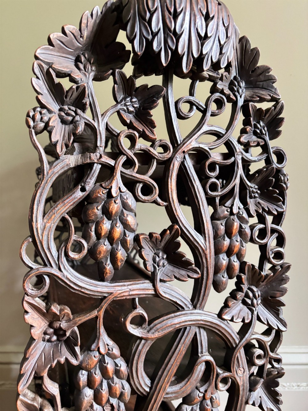 A mid-19th-century Anglo-Indian dark padauk wood open shelving unit with three tiers, intricate foliate carving, pierced aprons, and carved feet. View IX