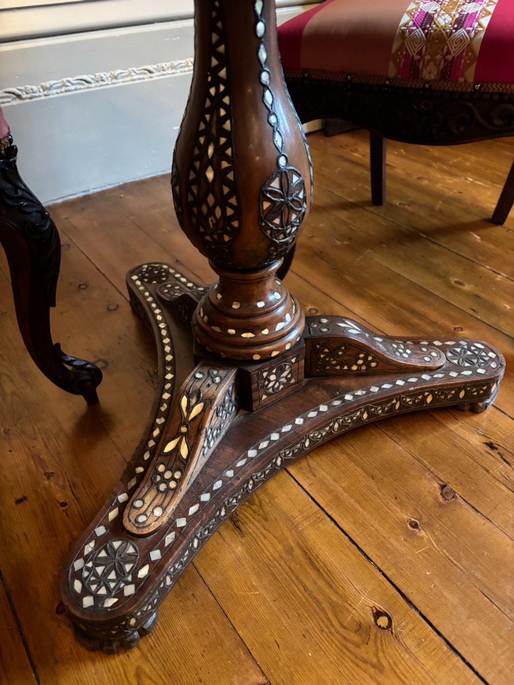 A 19th-century circular Anglo-Indian pedestal table made of dark hardwood with geometric mother-of-pearl inlay across the top, apron, turned column, and tripod base. View XI