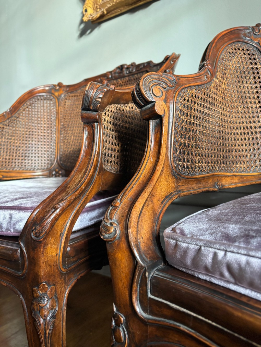 A pair of French Louis XV style carved wooden armchairs with woven cane backrests and purple velvet seat cushions resting on cabriole legs. View VII