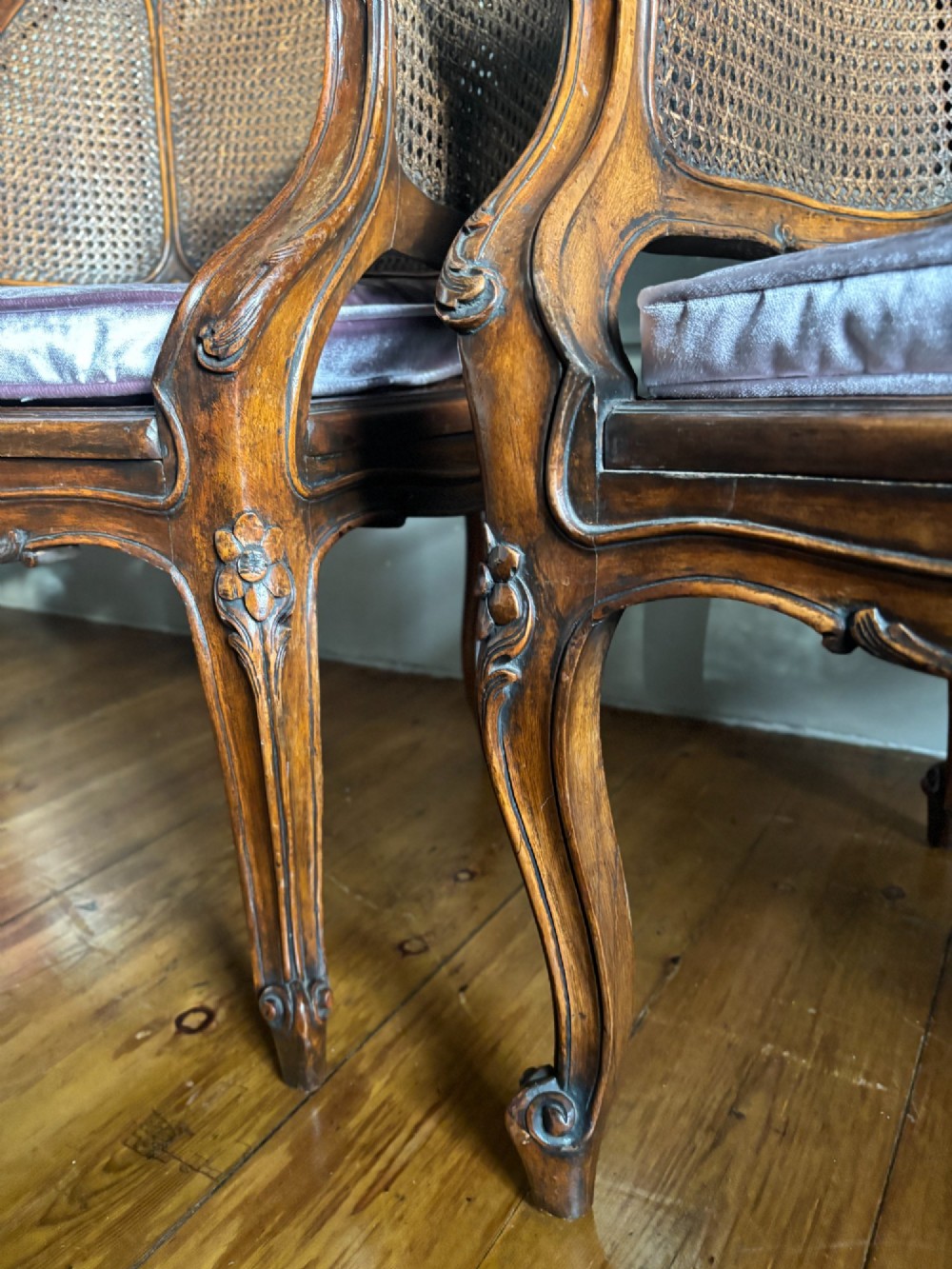 A pair of French Louis XV style carved wooden armchairs with woven cane backrests and purple velvet seat cushions resting on cabriole legs. View VIII