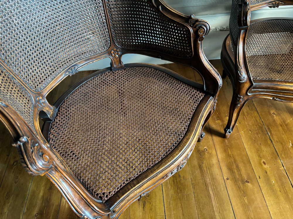 A pair of French Louis XV style carved wooden armchairs with woven cane backrests and purple velvet seat cushions resting on cabriole legs. View XIII