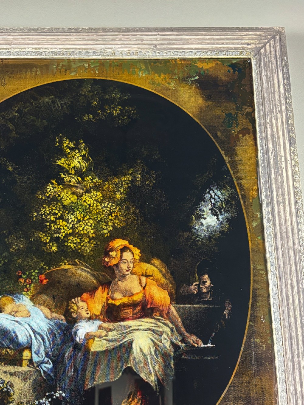 A rectangular framed Georgian reverse glass print depicting a classical maternal scene titled La Bonne Mere set within an oval border. View V