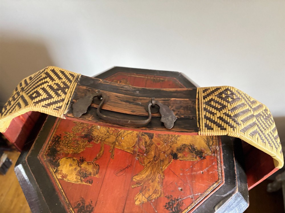 An octagonal three-tiered Chinese lacquer dowry basket decorated with hand-painted narrative panels and a high arched handle. View VIII