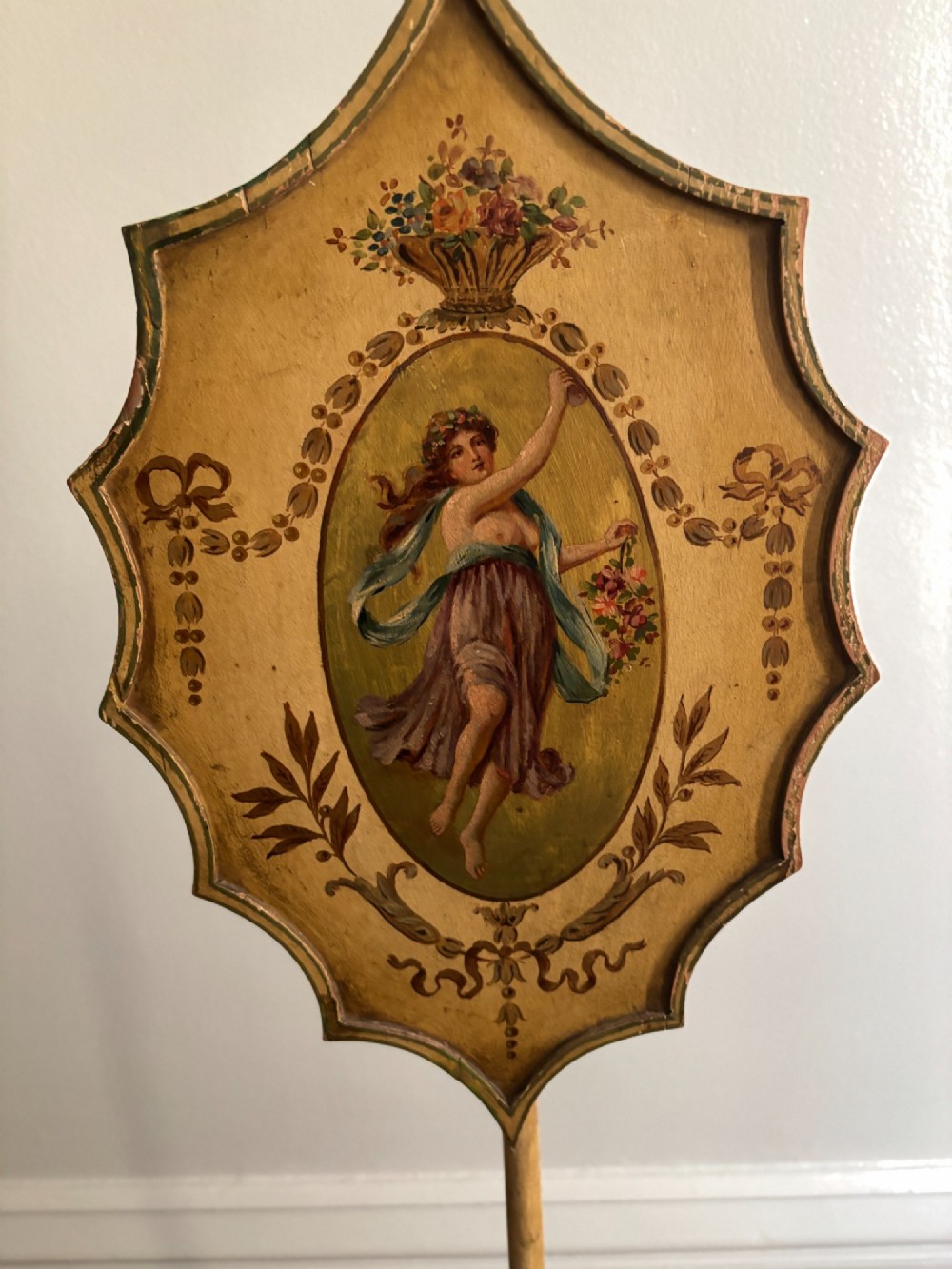 A pair of antique Georgian yellow painted pole screens featuring oval painted classical figurative vignettes and tripod bases with spade feet. View VIII