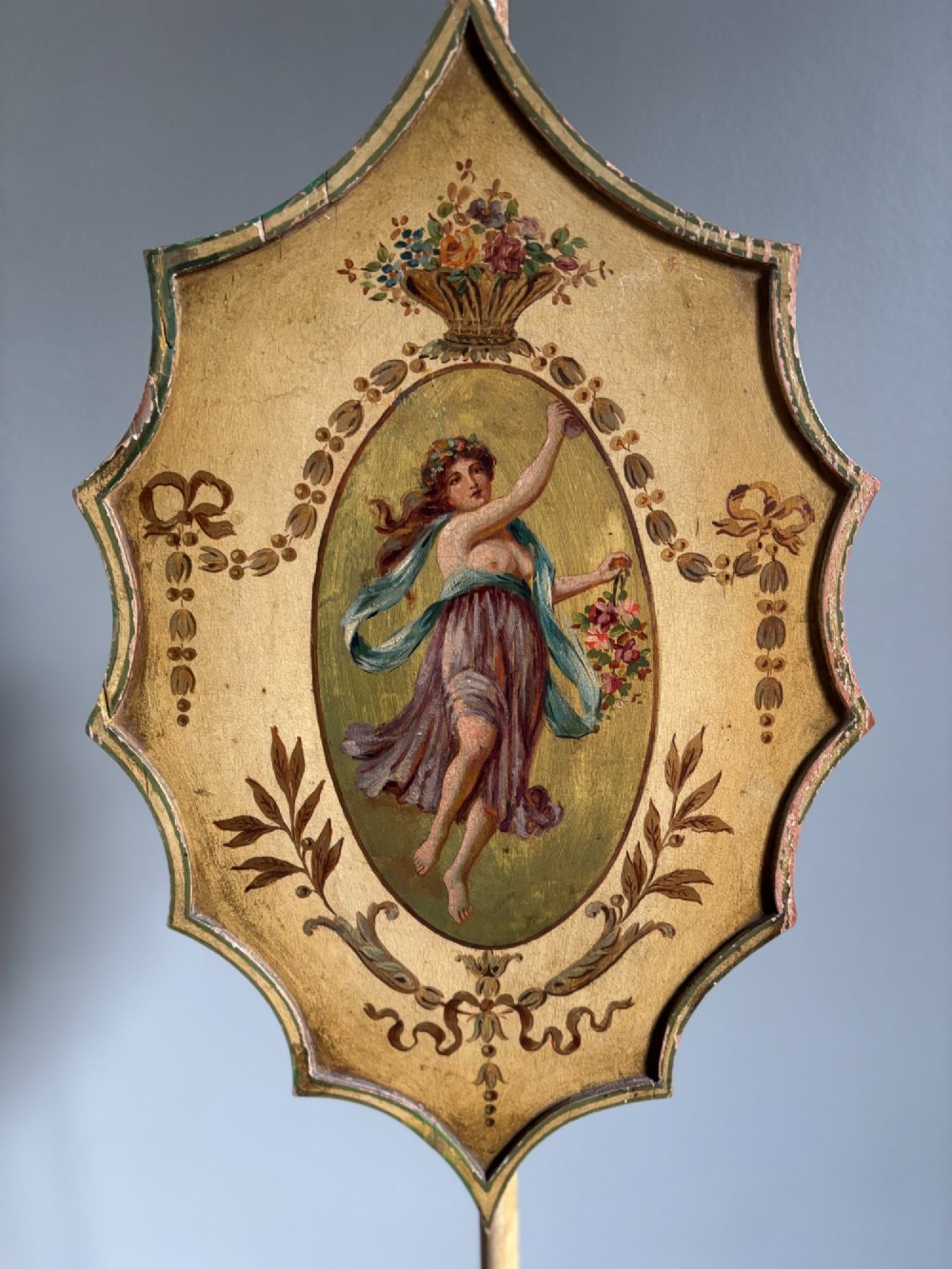 A pair of antique Georgian yellow painted pole screens featuring oval painted classical figurative vignettes and tripod bases with spade feet. View XIII
