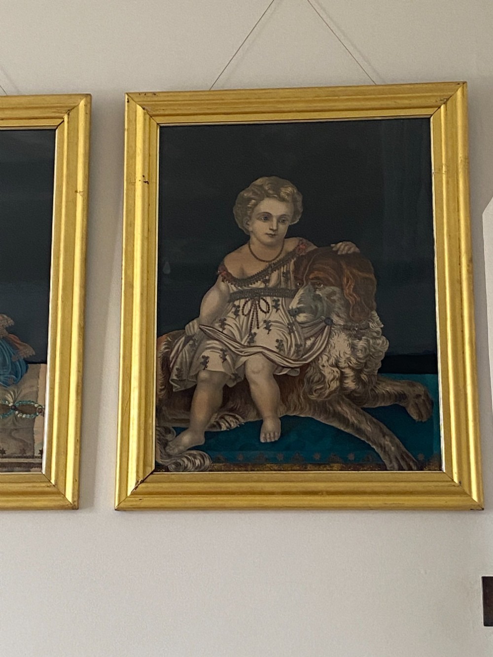 A pair of gilt-framed circa 1820 prints depicting young children with animals against dark backgrounds with metallic clothing embellishments. View VII