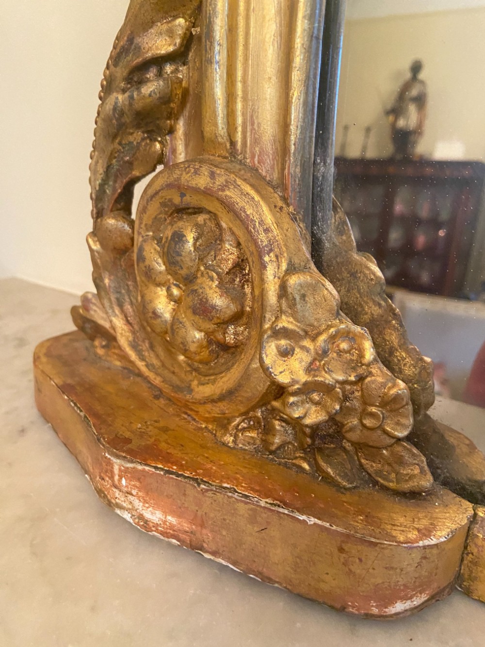 A large mid-nineteenth century giltwood overmantel mirror featuring a waisted arched frame, carved pediment cresting, and scroll motifs at the base. View II