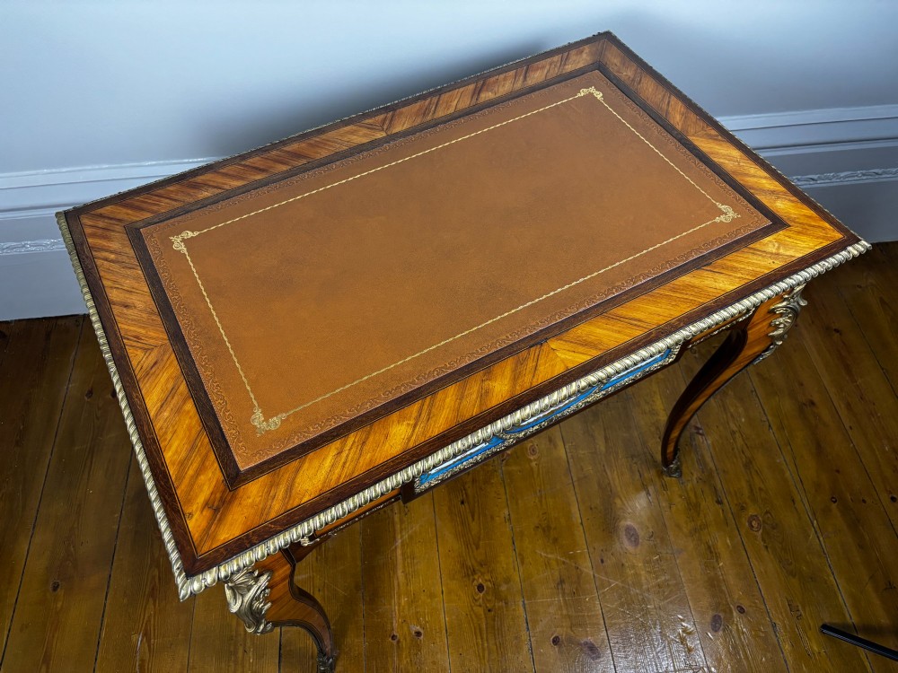 A Louis XV style rosewood writing table featuring cabriole legs, gilt bronze ormolu mounts, and blue porcelain plaques set into the frieze. View XI