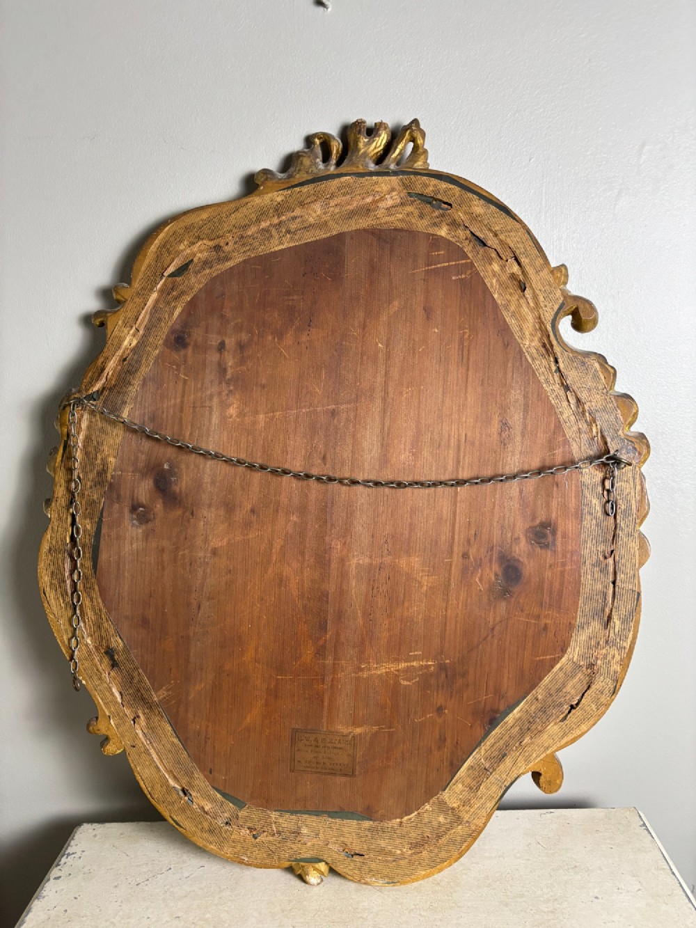 An oval Edwardian portrait of a young boy wearing a white sailor suit, set within a gilt scrollwork frame. View VIII