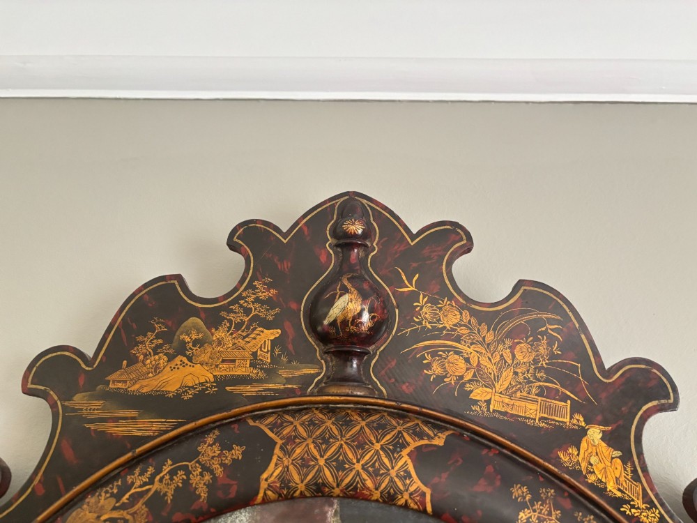 A pair of tall arched Queen Anne style wall mirrors featuring black japanned frames decorated with gilded chinoiserie motifs and cut glass crests. View VI
