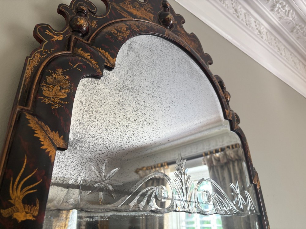 A pair of tall arched Queen Anne style wall mirrors featuring black japanned frames decorated with gilded chinoiserie motifs and cut glass crests. View VII