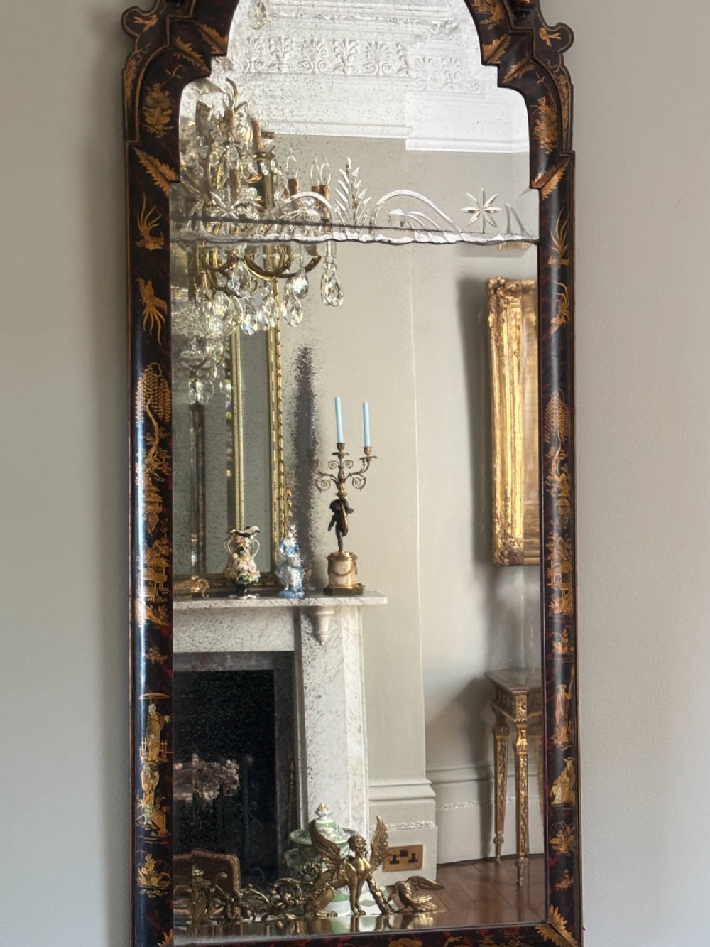 A pair of tall arched Queen Anne style wall mirrors featuring black japanned frames decorated with gilded chinoiserie motifs and cut glass crests. View VIII