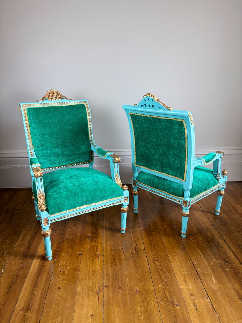 A pair of 19th-century French open armchairs featuring carved turquoise painted frames with gold gilt accents and emerald green velvet upholstery. View VII