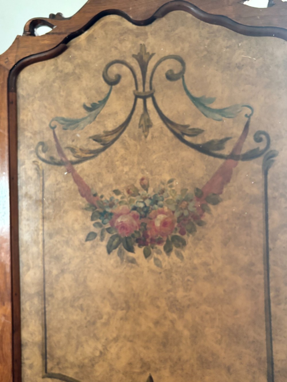 A three-panel French walnut folding screen featuring hand-painted pastoral scenes, floral garlands, scrollwork, and carved cresting. View II