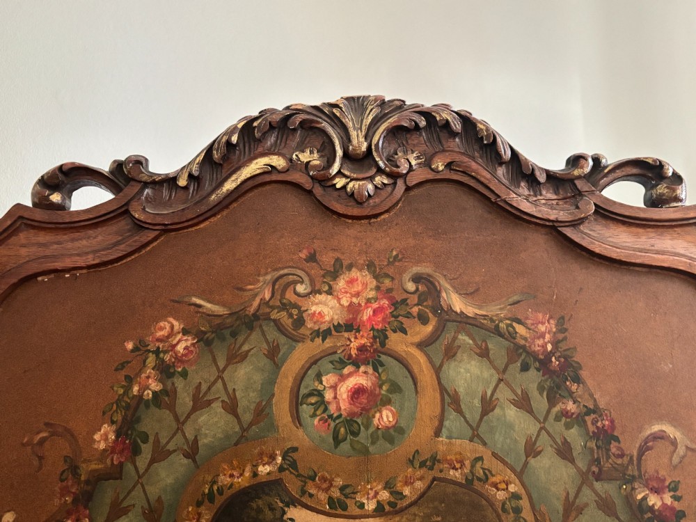 A three-panel French walnut folding screen featuring hand-painted pastoral scenes, floral garlands, scrollwork, and carved cresting. View XI