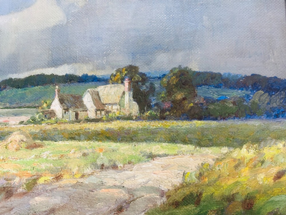An Edwardian oil painting on board depicting a rural landscape with haystacks, cottages, and clouds set within a moulded frame. View II