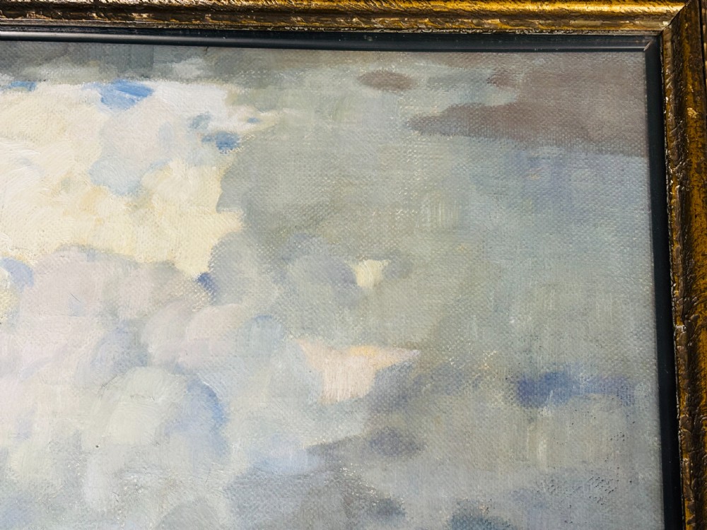 An Edwardian oil painting on board depicting a rural landscape with haystacks, cottages, and clouds set within a moulded frame. View IV