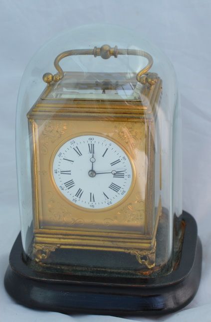 A Gilt Carriage Clock Under Its Original Glass Dome