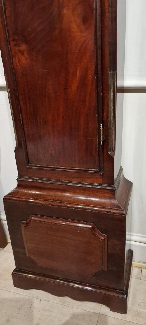 fig 1. An 18th-century Georgian mahogany longcase clock with an arched silvered brass dial, fluted hood columns, and three brass ball-and-spire finials.
