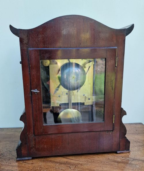 fig 1. A Victorian carved mahogany fusee bracket clock featuring a circular white dial with Roman numerals inscribed Edw. Funnell Brighton within a brass bezel.