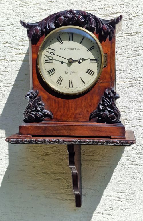 fig 2. A Victorian carved mahogany fusee bracket clock featuring a circular white dial with Roman numerals inscribed Edw. Funnell Brighton within a brass bezel.