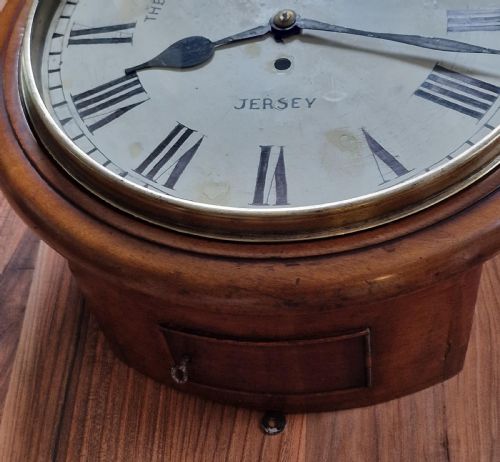 fig 1. A circular mahogany fusee wall clock featuring a white painted dial with Roman numerals, black hands, and a brass bezel surround.