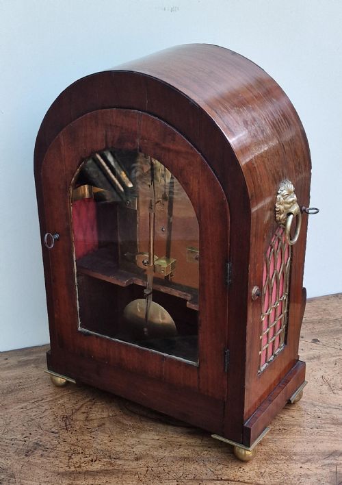 fig 1. An arched rosewood bracket clock with brass floral inlay, white circular dial signed S. Simpson Southampton with Roman numerals, and side drop handles.