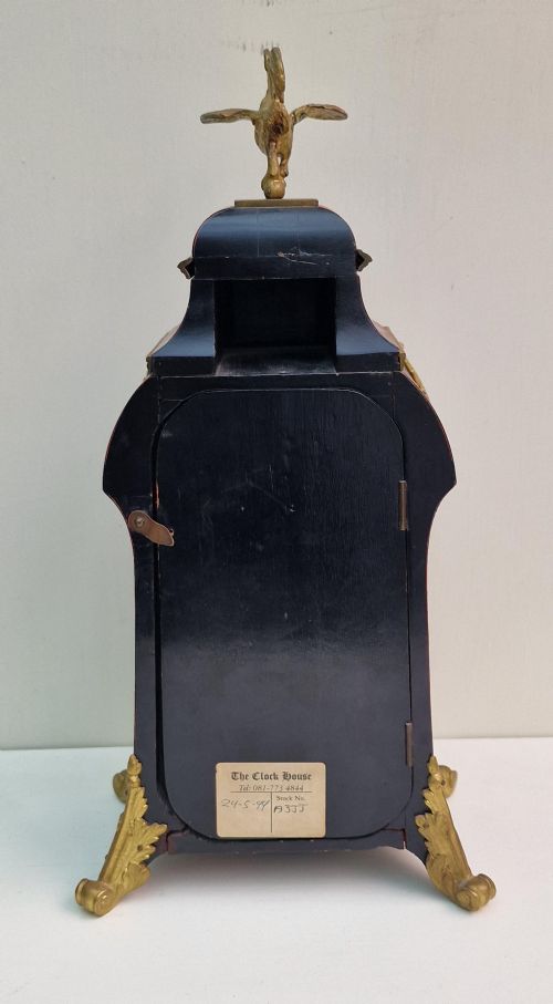 fig 1. A French Louis XV revival mantel clock featuring red tortoiseshell veneer, gilt bronze ormolu mounts, a top bird finial, and an enamel cartouche dial with blue Roman numerals.