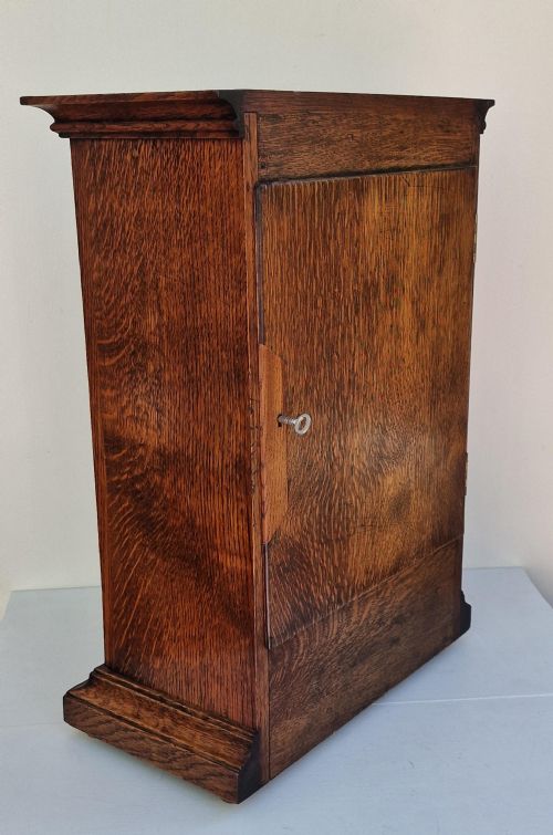 fig 1. A Second World War period oak RAF officers mess mantel clock featuring a white dial with Roman numerals and Royal Air Force crest.