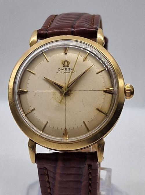 A 1950s vintage Omega automatic wristwatch crafted with a 9K gold case and brown leather strap, set inside a red presentation box. View VII