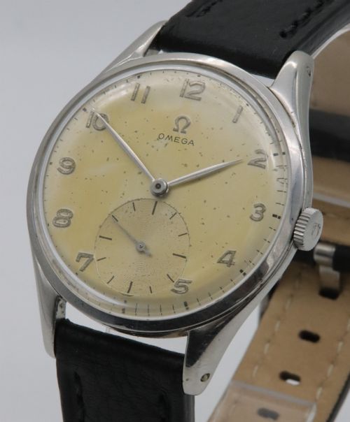 fig 1. A 1947 Omega wristwatch featuring a circular stainless steel case, a patinated cream dial with Arabic numerals, a sub-seconds dial, and a black leather strap.