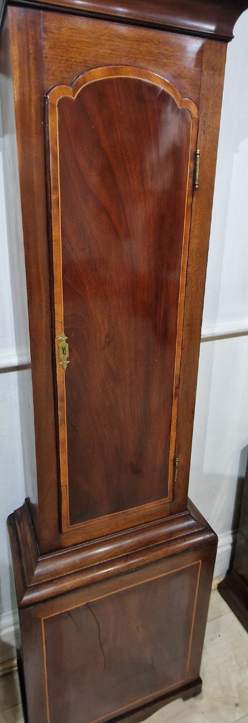 A Georgian mahogany grandmother clock featuring a swan-neck pediment, brass rosettes, an engraved brass and silvered dial, and an inlaid wooden trunk case. View VIII