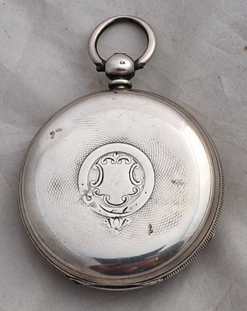 fig 1. An antique open-face silver pocket watch featuring a white enamel dial with Roman numerals, a subsidiary seconds dial, and an accompanying brass winding key.
