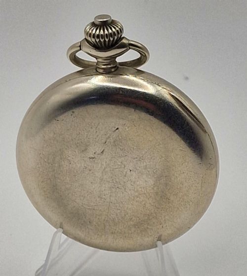 fig 1. A vintage military chronograph pocket watch featuring a silver-tone metal case, a black dial with luminous Arabic numerals, two sub-dials, and an onion-style crown.