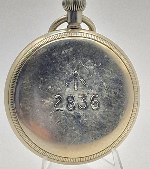 fig 1. An open-face vintage Terminus military pocket watch featuring a white enamel dial with bold black Arabic numerals, a sub-seconds subdial at six oclock, and a reeded bezel.