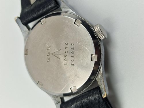 fig 1. A 1940s Record military wristwatch featuring a black dial with luminous numerals, broad arrow mark, sub-seconds dial, and a black leather strap.