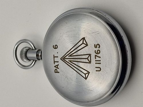 fig 1. A circular vintage Waltham Admiralty Pattern No. 6 naval pocket timer featuring a chrome-plated metal casing and an aged cream dial with black and red markings.