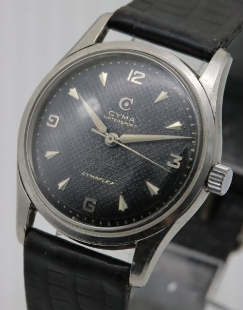 fig 1. A 1950s Cyma Watersport Cymaflex wristwatch featuring a round stainless steel case, a black textured waffle dial with silver markers, and a black strap.