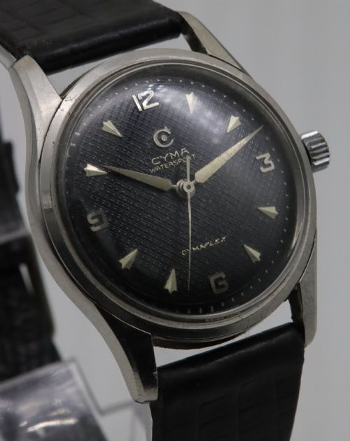 fig 2. A 1950s Cyma Watersport Cymaflex wristwatch featuring a round stainless steel case, a black textured waffle dial with silver markers, and a black strap.